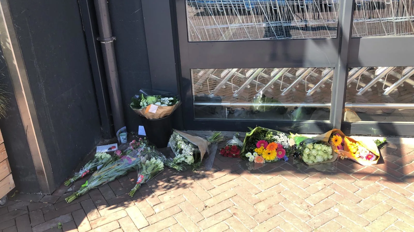 Verslagen dorpelingen leggen bloemen bij supermarkt in Hoogkerk waar tiener werd doodgestoken: 'Dit is geen normale wereld meer'