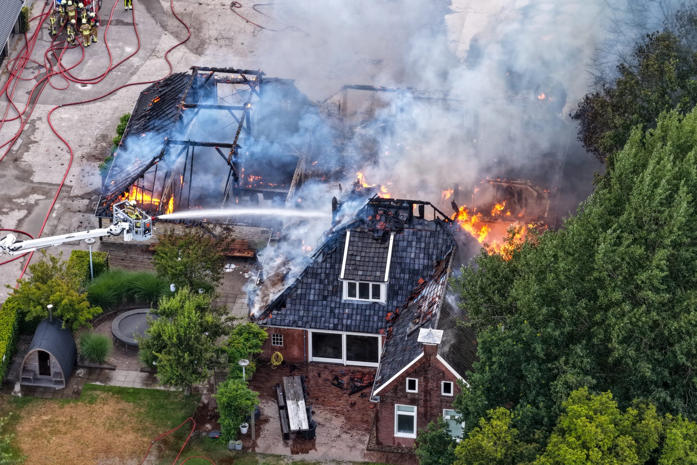 Grote uitslaande brand in schuur in Sumar slaat over op paardenstallen