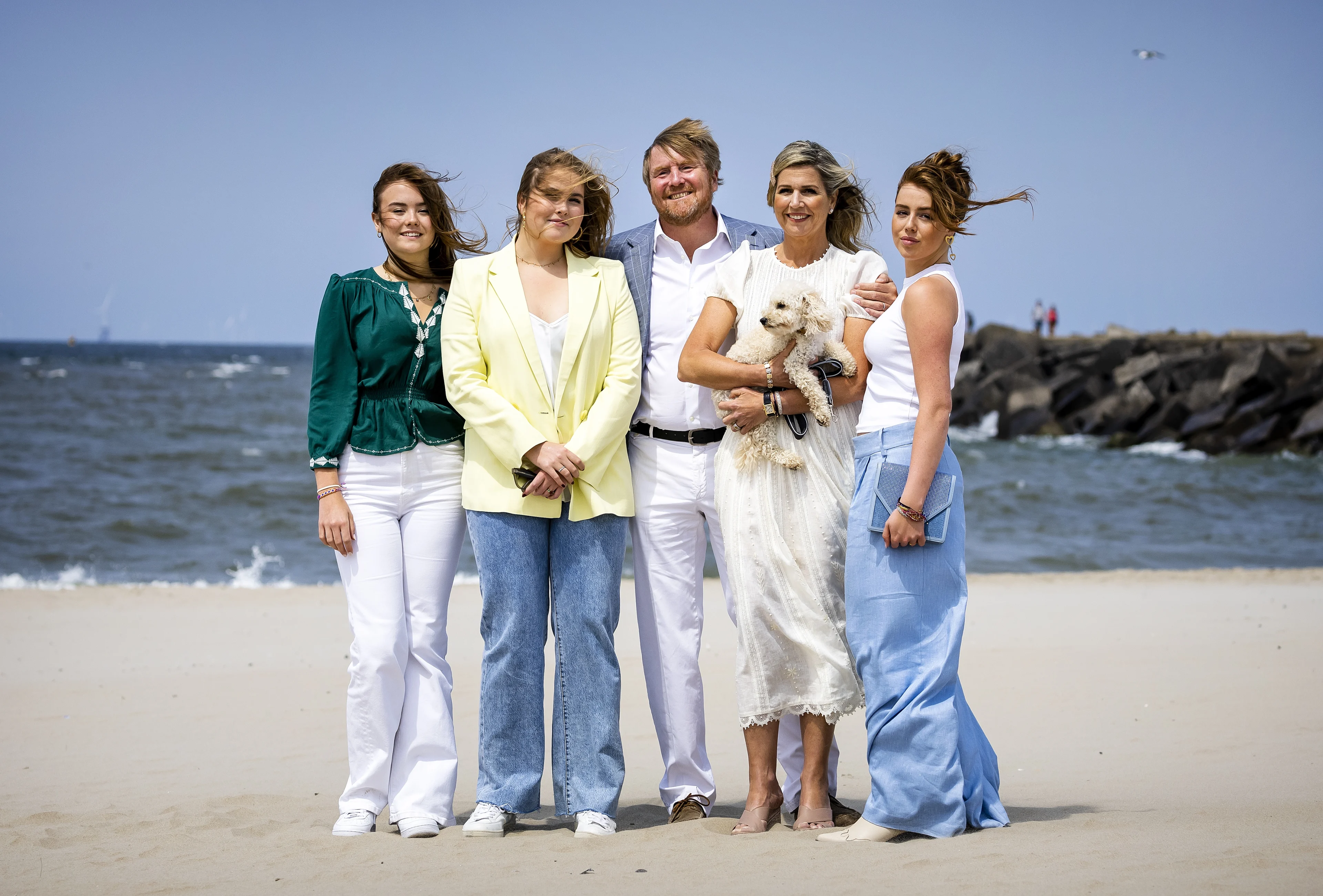Oranjes poseren op winderig strand Den Haag tijdens zomerfotosessie