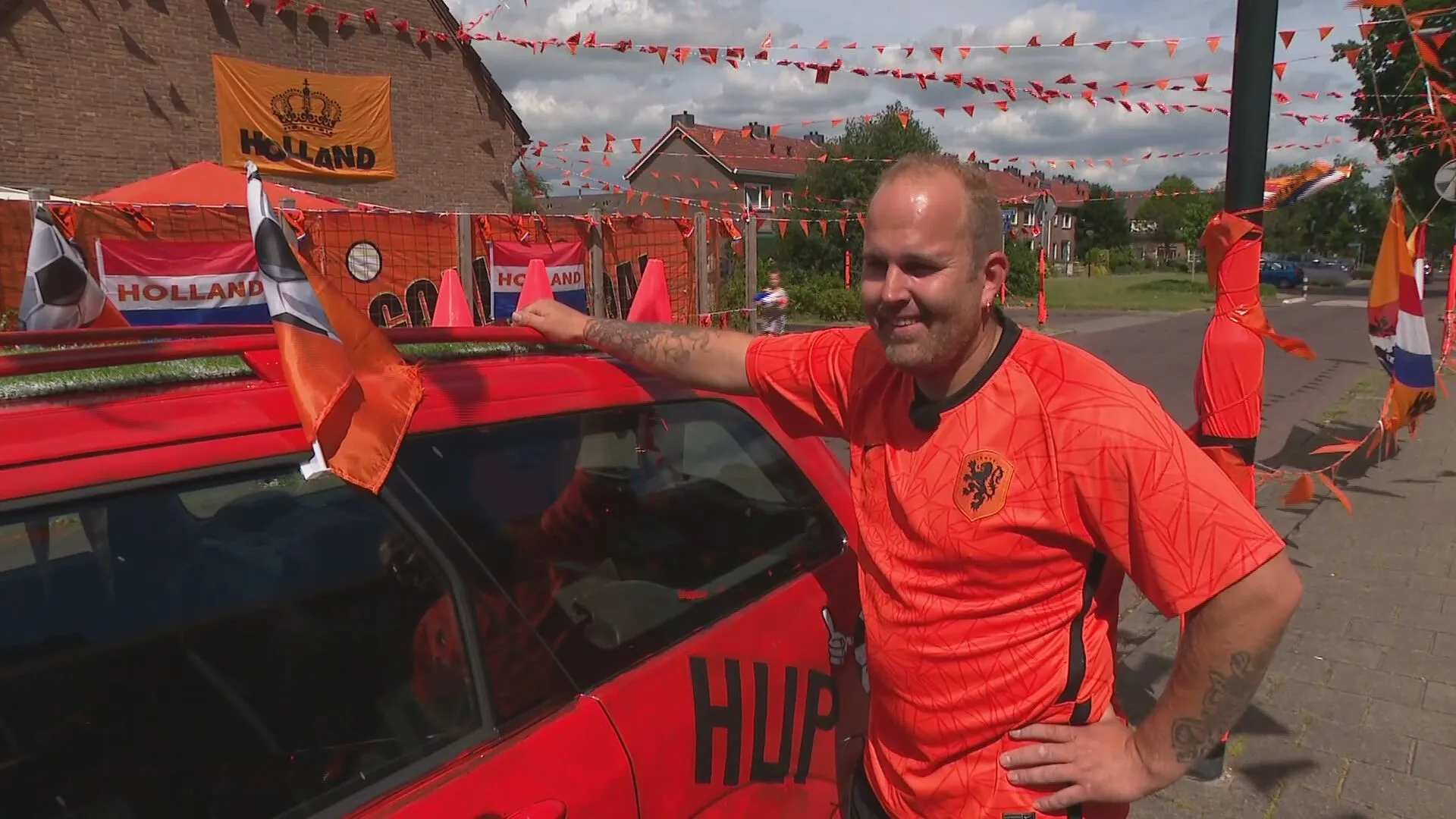 Oranjefan Ringo een blikvanger in Apeldoorn: oranje auto en kunstgras op het dak