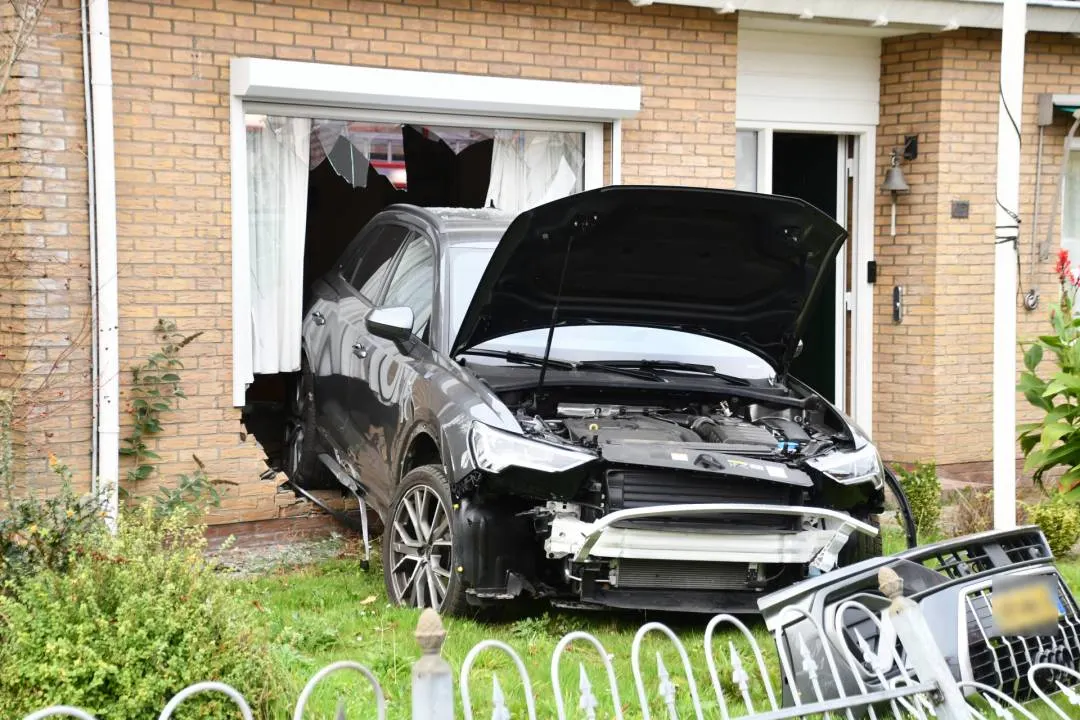 Auto rijdt achteruit de gevel in van woning in Heinkenszand