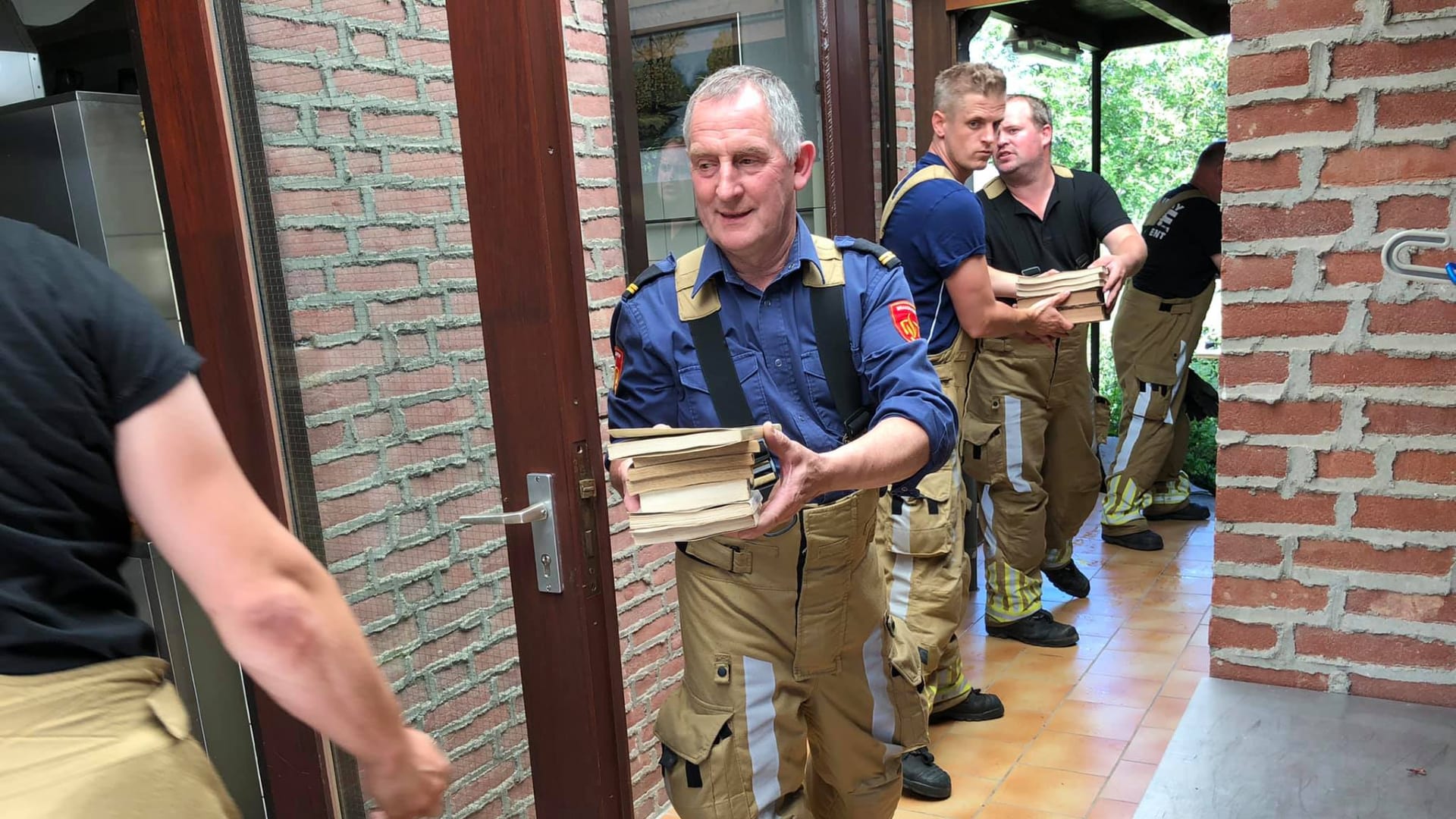 Brandweer helpt nonnen uit Sint Odiliënberg om eeuwenoude boeken van stijgende water te redden
