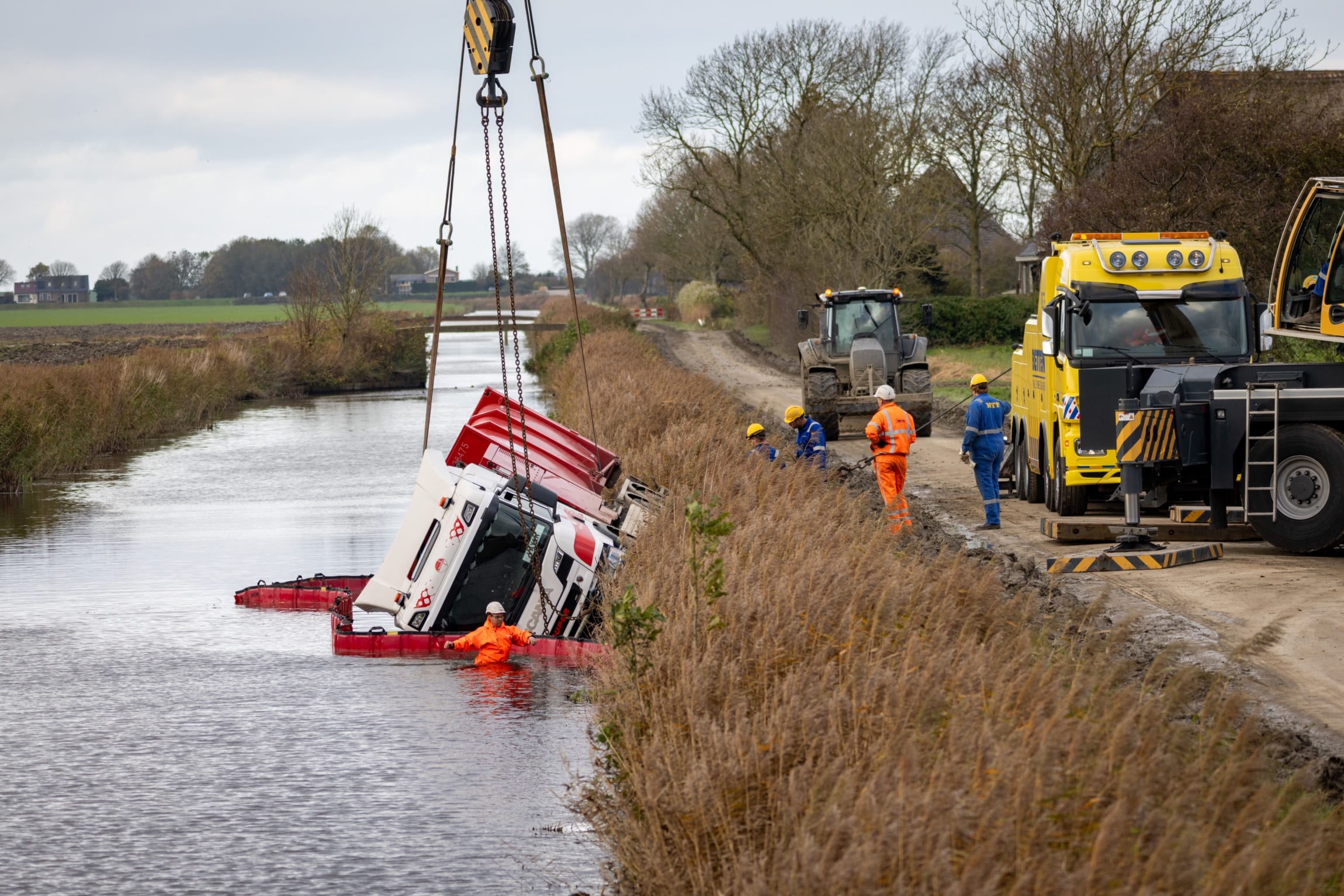 Vuilniswagen belandt volledig in het water na glijpartij Sint Jacobiparochie