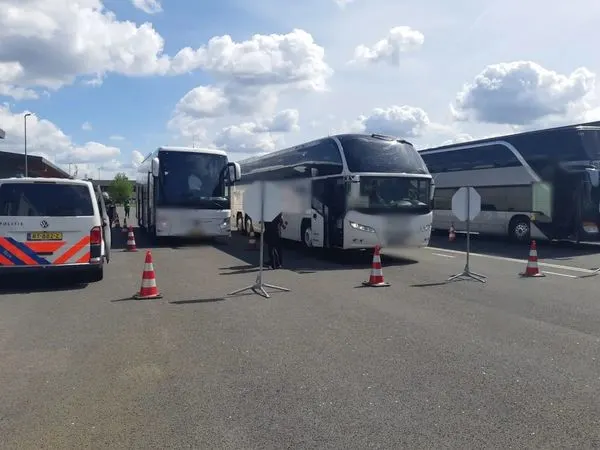 Beschonken buschauffeur loopt tegen de lamp, touringcar zit vol met kinderen