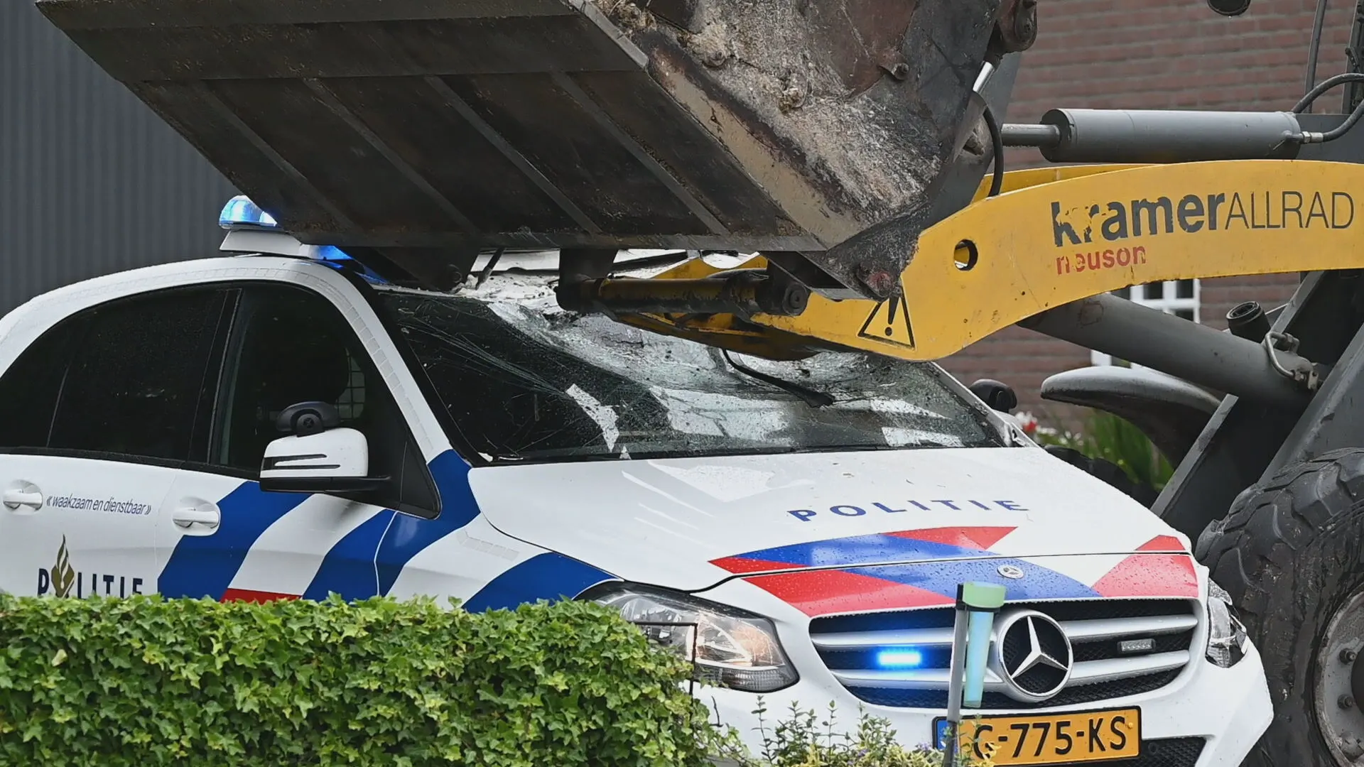 Man sloopt politieauto met graafmachine in Tilburg