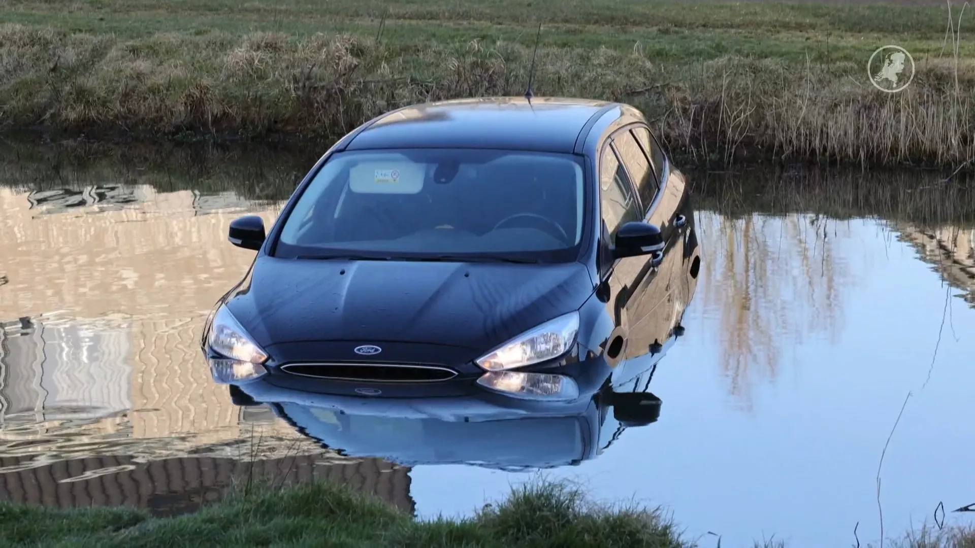 Auto met kinderen rolt water in nadat vader handrem vergeet