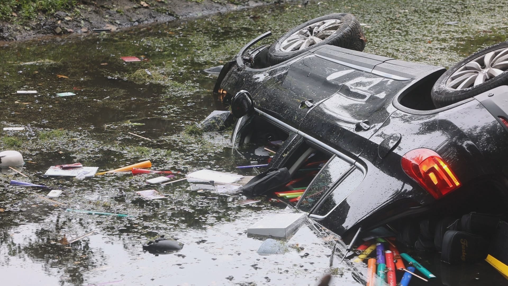 Heldhaftige omstanders springen water in om zinkende automobilist te redden