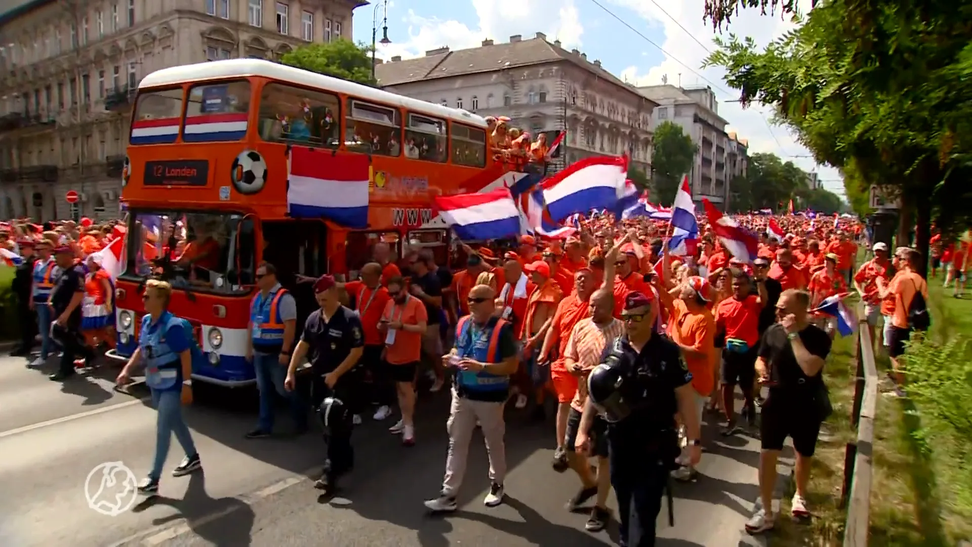 Oranjefans na feest in parade op weg naar stadion in Boedapest