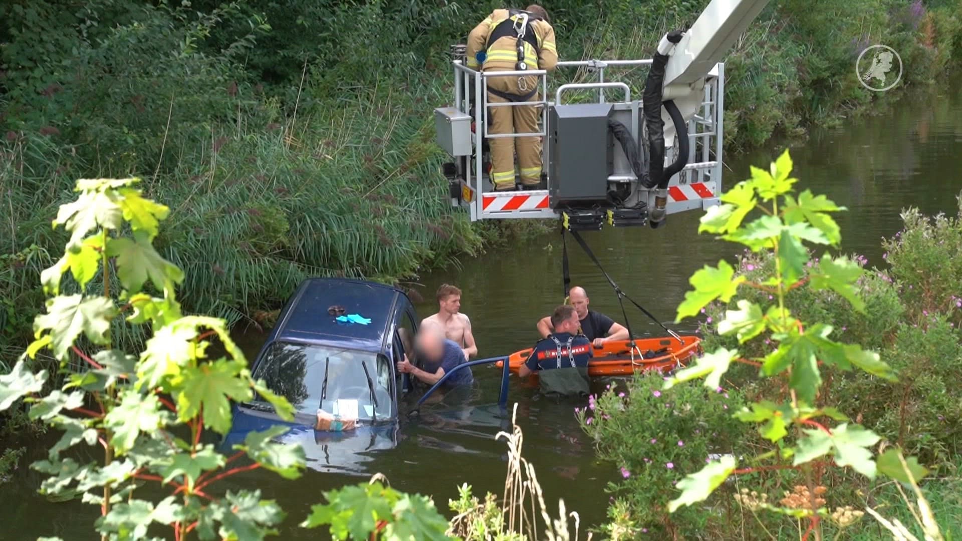 Man raakt te water, andere man helpt hem uit het water