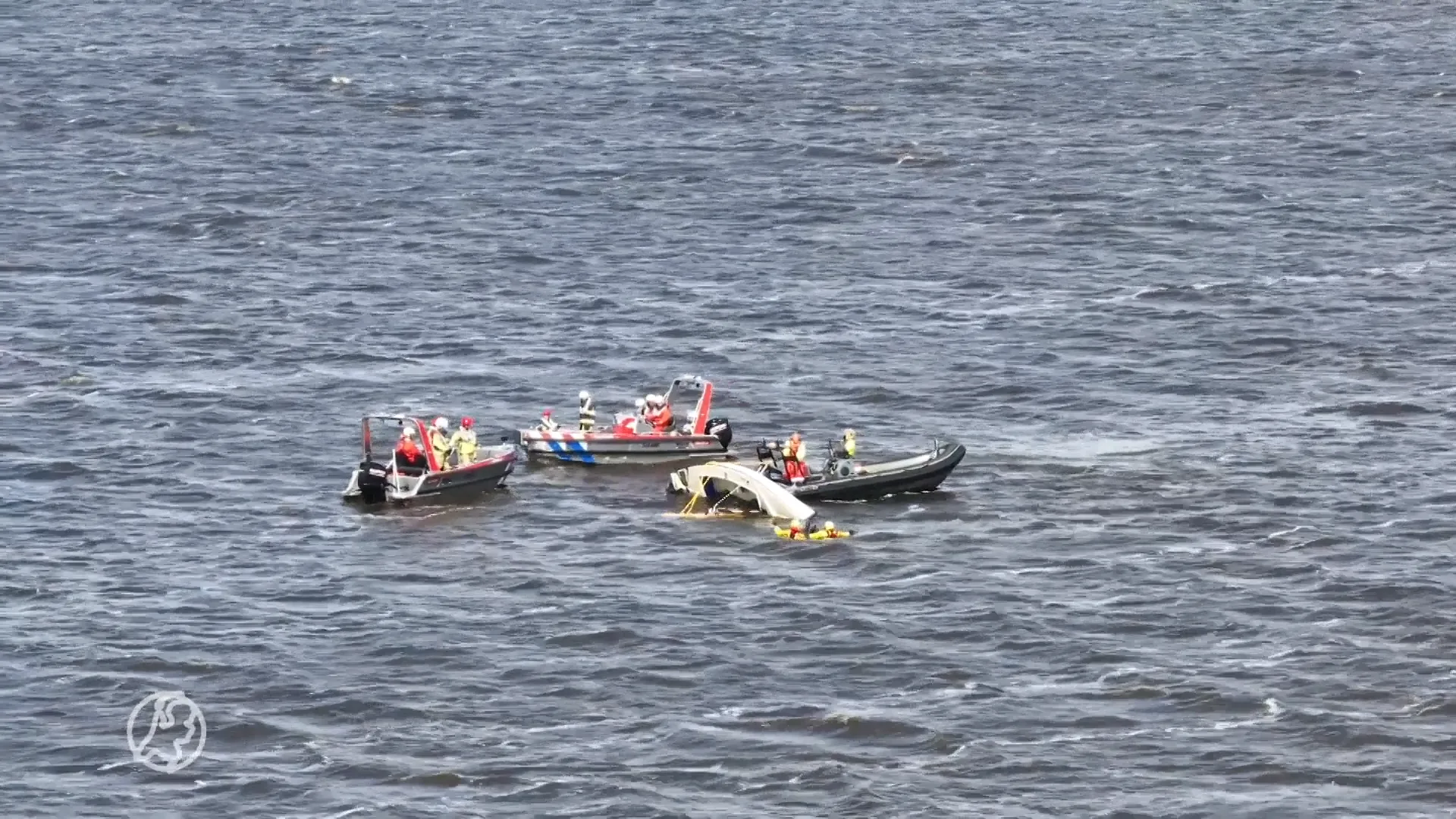 Zeilboot omgeslagen door harde wind, opvarenden uit water gered