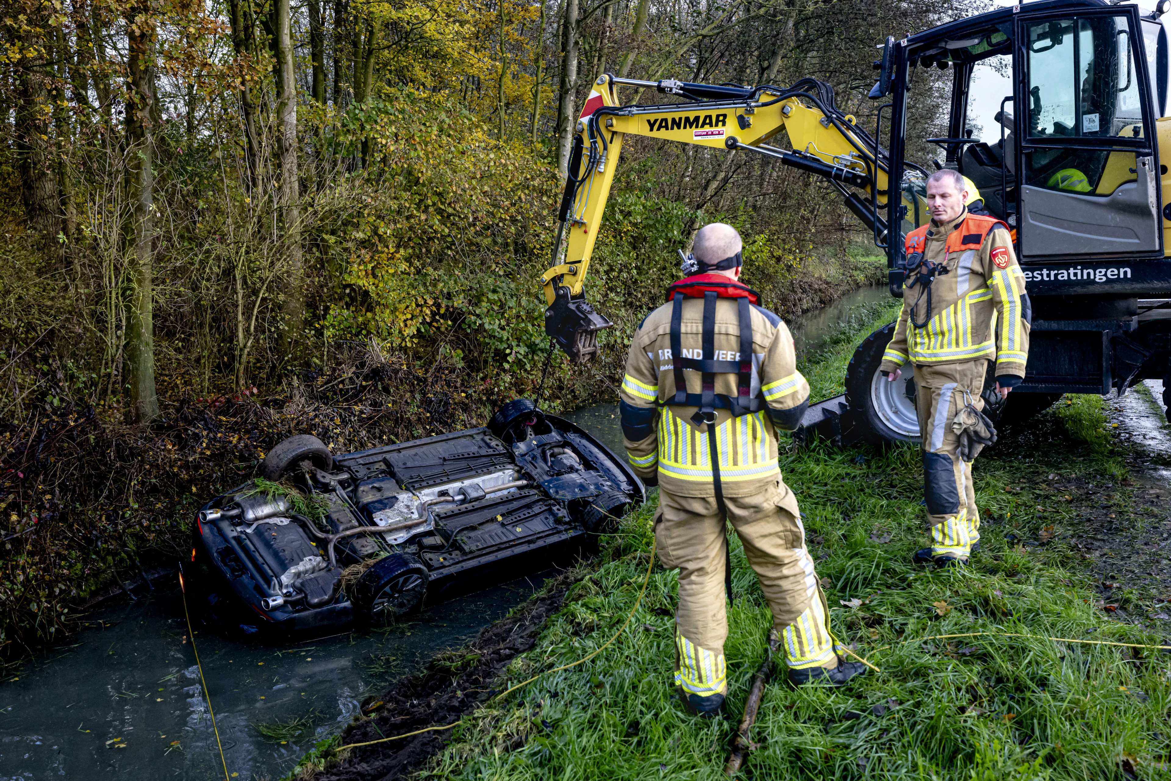 Vrouw en twee kinderen in auto op de kop in sloot Uitwijk, zeker één kind gereanimeerd