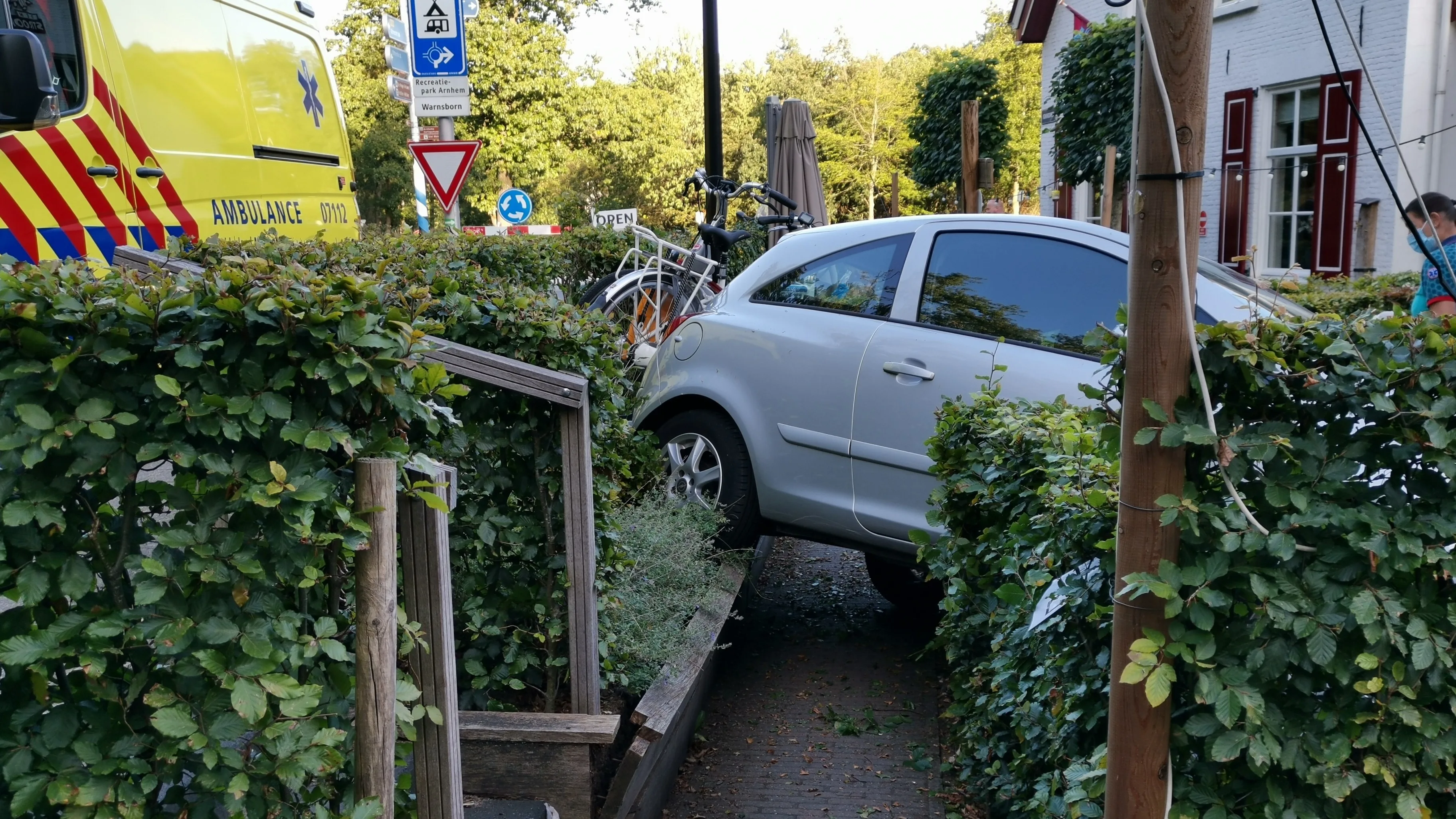 Vrouw rijdt met auto terras Arnhems pannenkoekhuis op