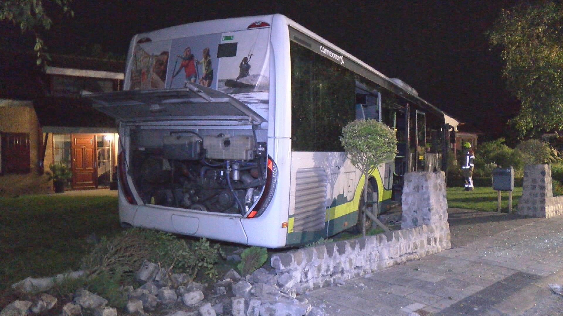 Complete lijnbus knalt door muurtje heen en rijdt tuin in Goes in