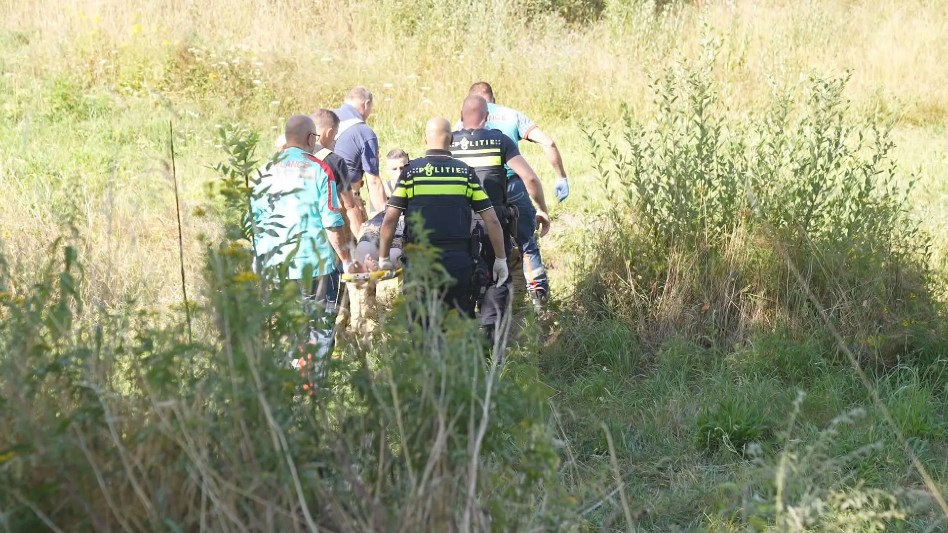 Vrouw stort met scootmobiel van talud en verdwijnt in het hoge gras
