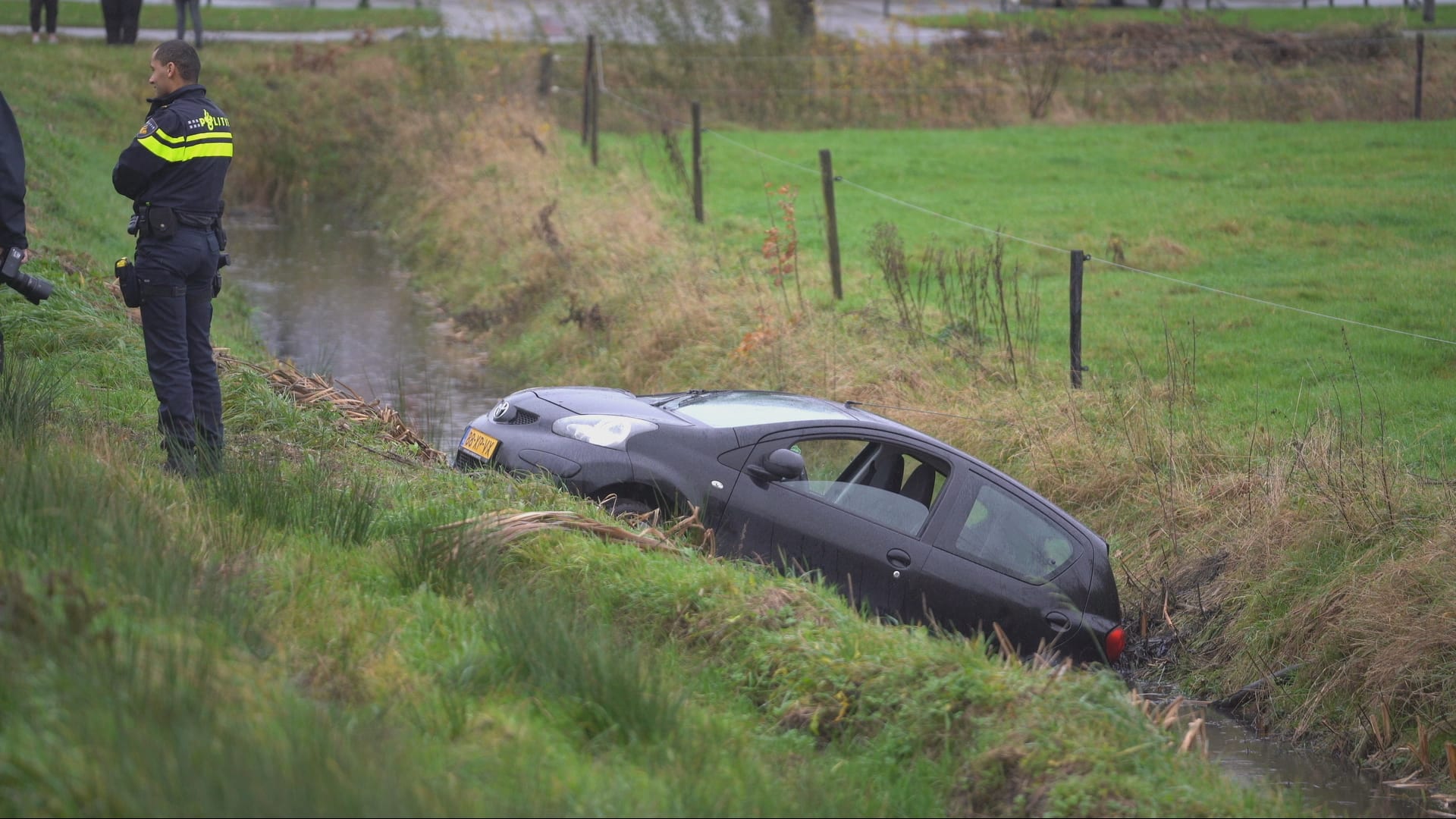 Auto in sloot bij Leek: vrouw moet in water wachten op hulp