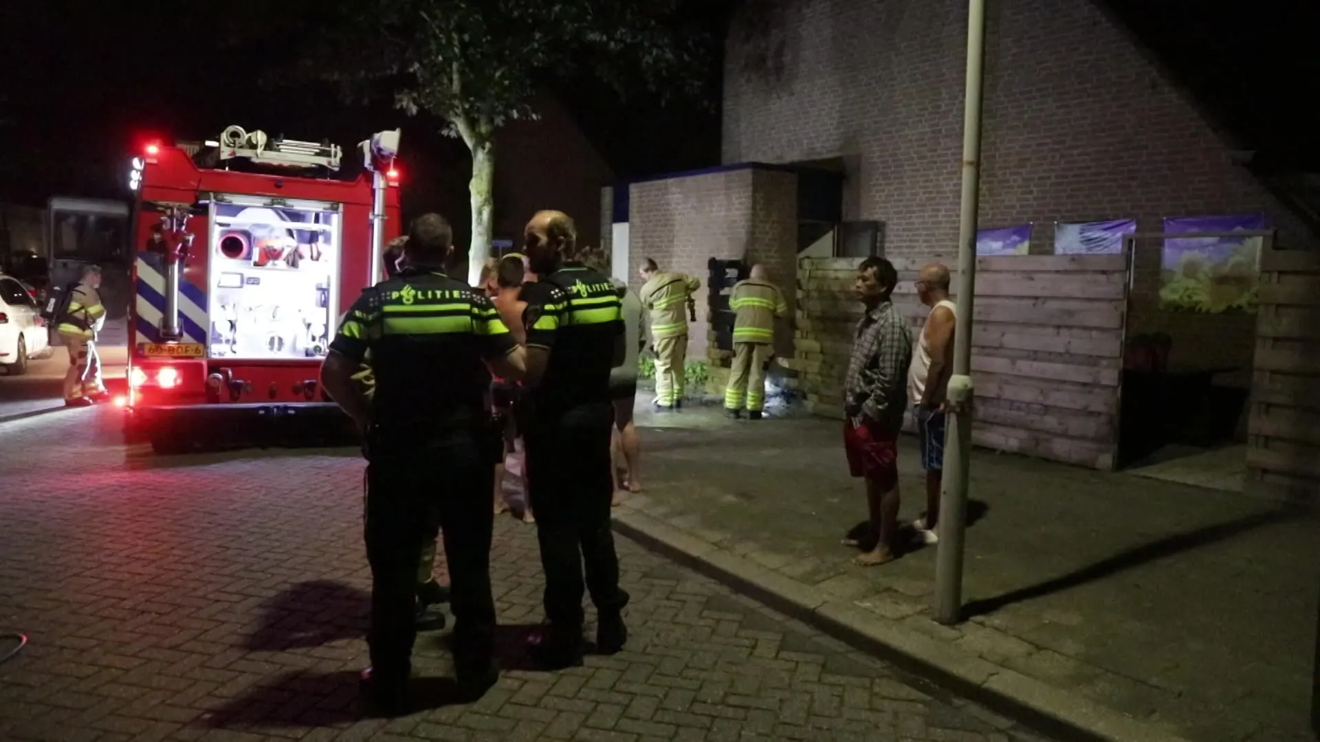 Mannen in ondergoed blussen brand bij buurman met tuinslang