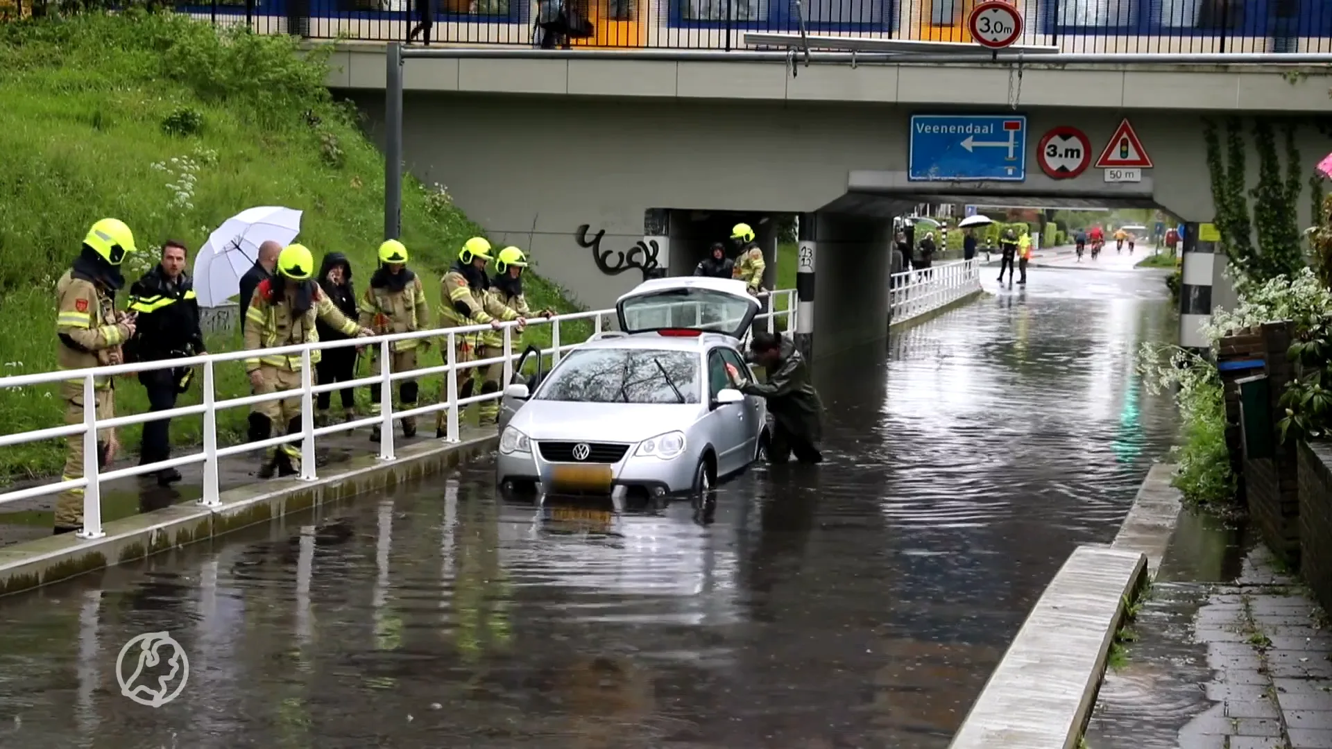 Auto zit vast in overstroomd viaduct