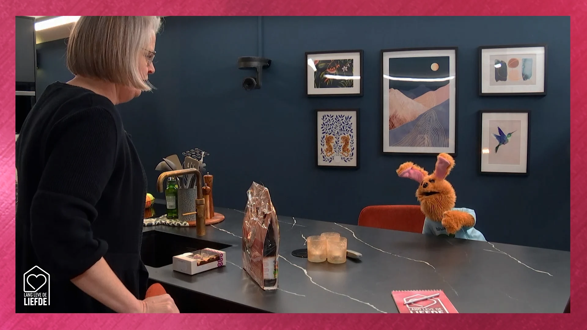 Saskia komt het huis binnen en wordt begroet door een HANDPOP