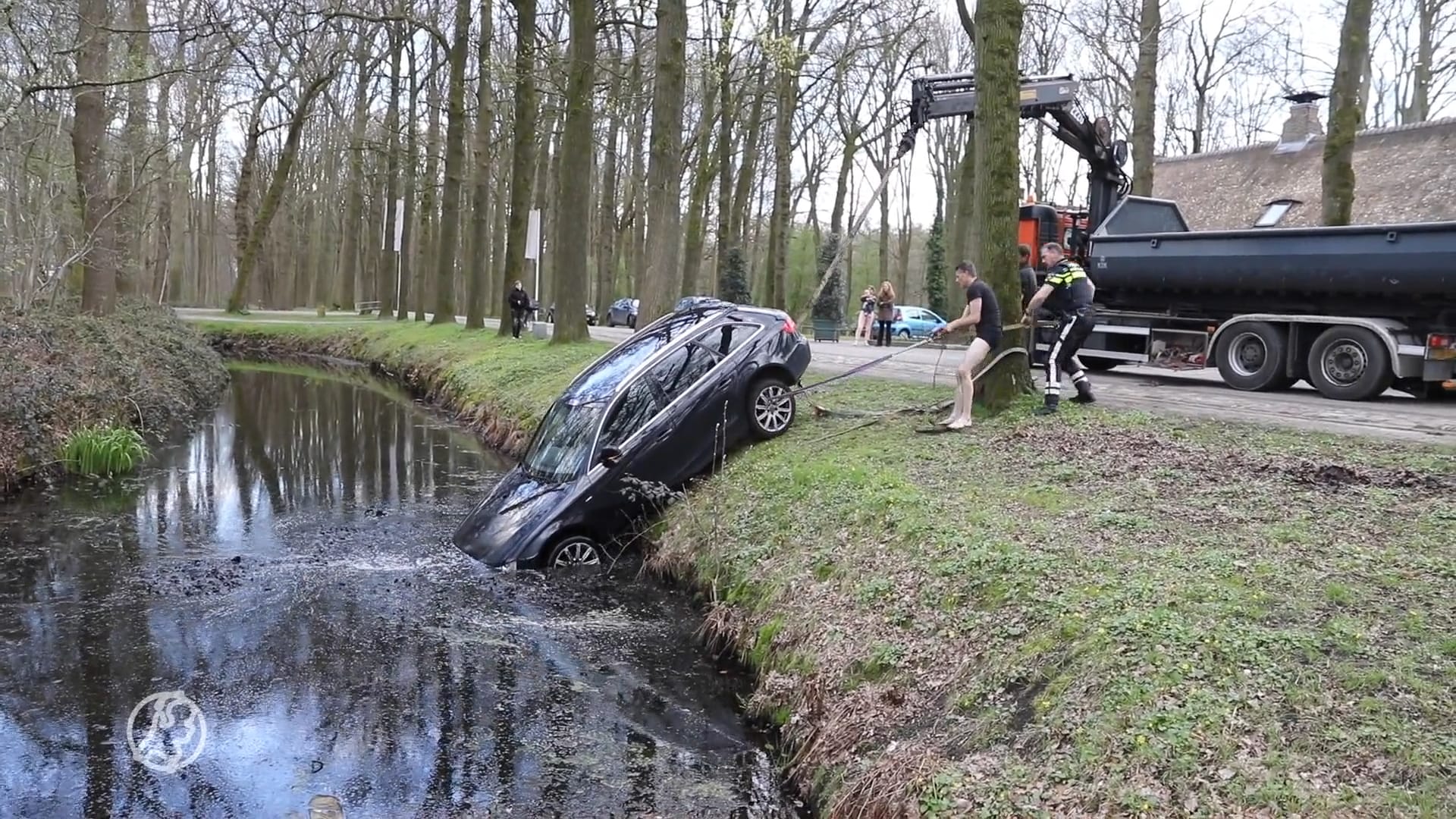 Man vergeet handrem en ziet hoe auto in de gracht rolt
