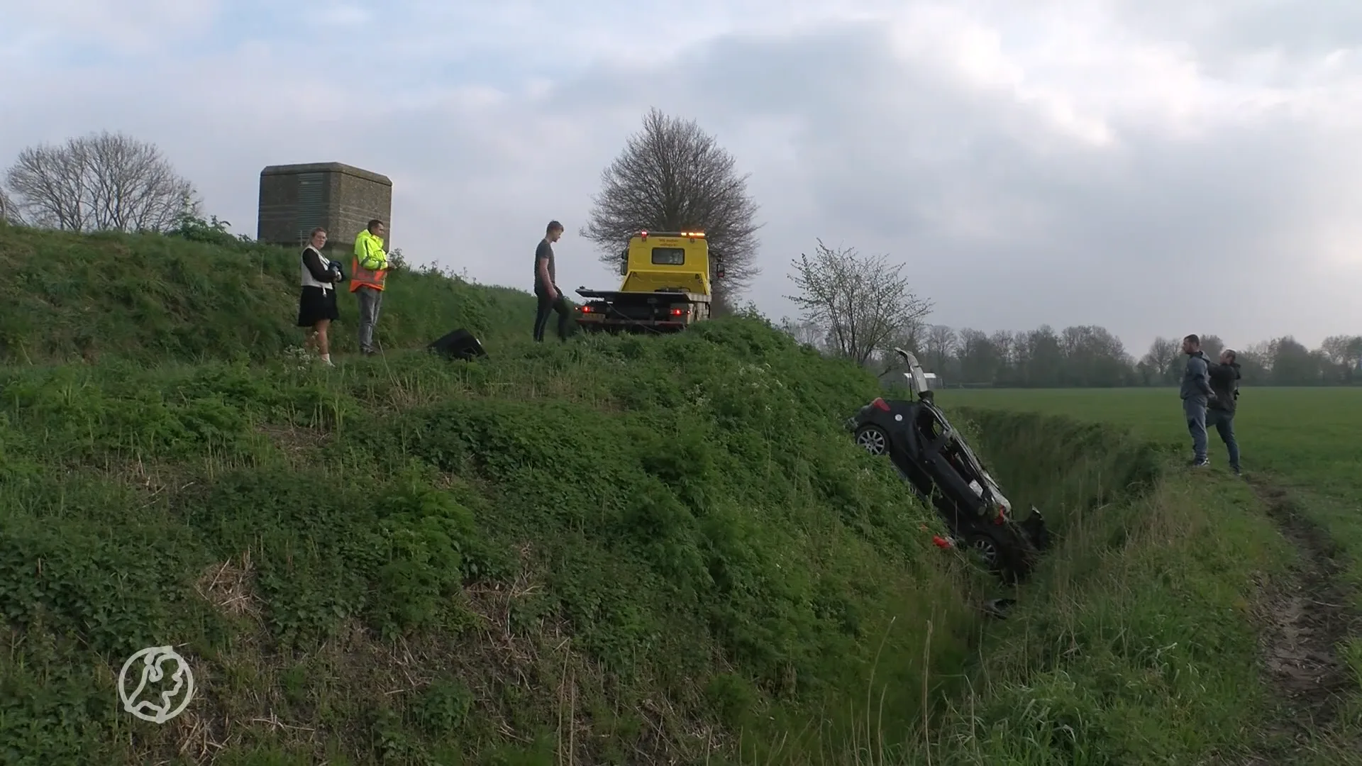 Auto op kop in sloot naast dijk