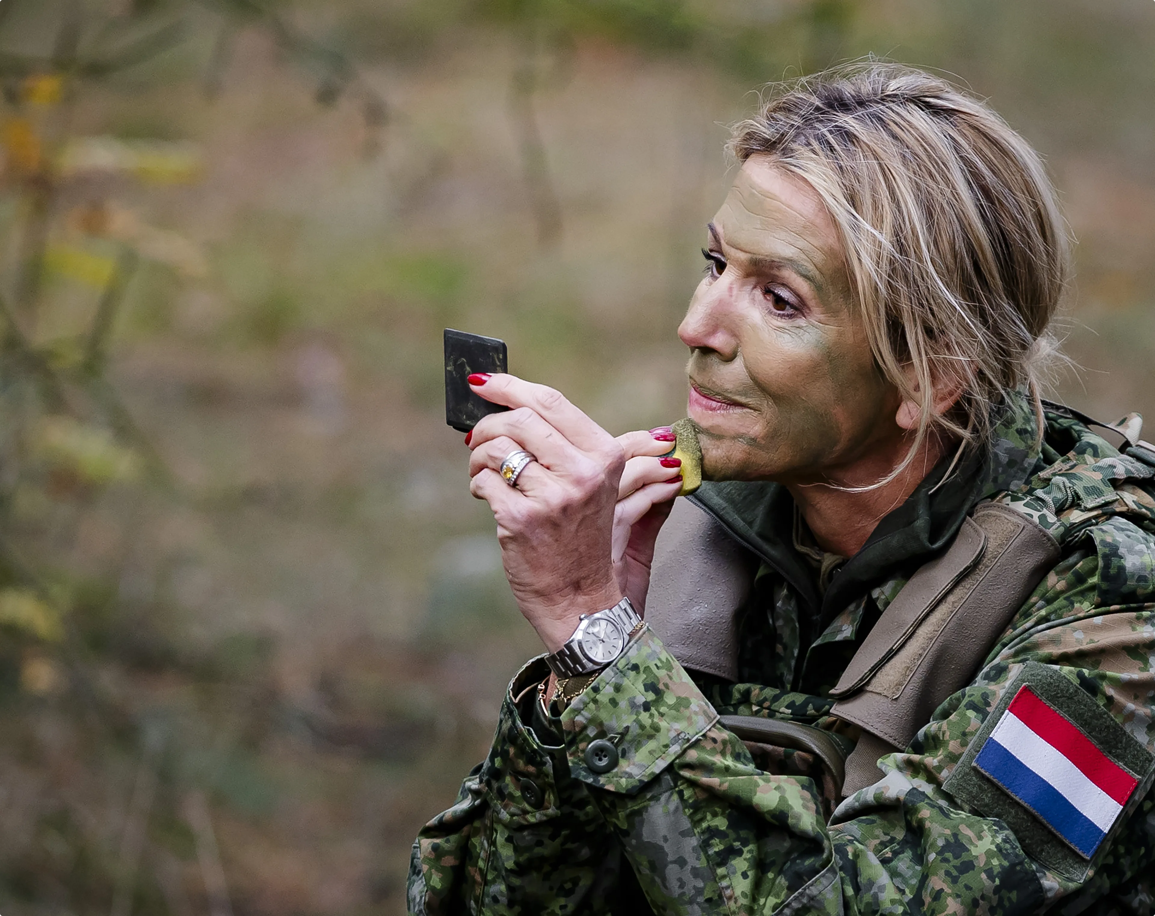 Koningin Maxima schminkt haar gezicht tijdens een bezoek aan het bivak van het Dienjaar Koninklijke Marechaussee (2025) - Bron ANP