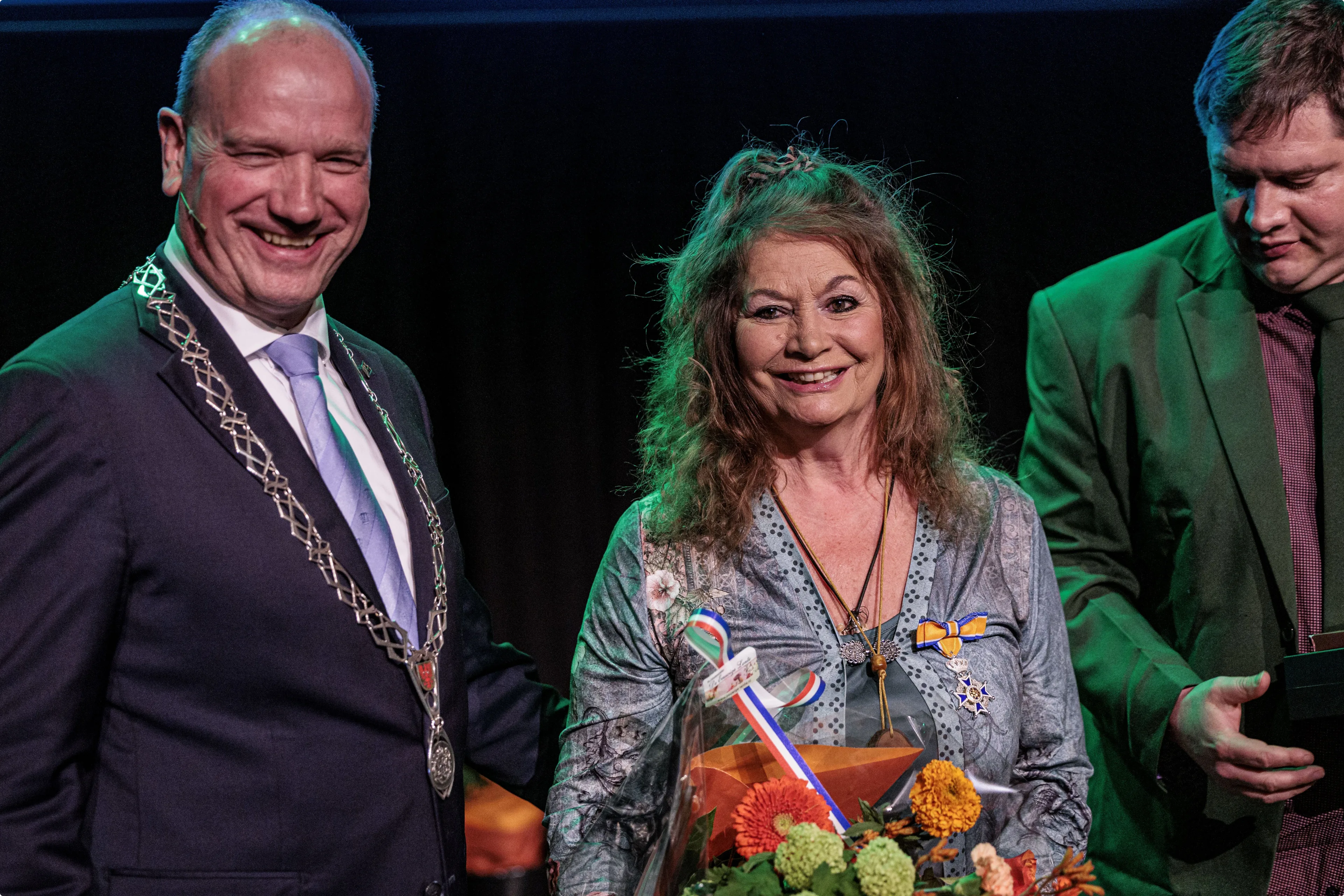Burgemeester Ton Heerts, Belinda Meuldijk en zoon Yoshi tijdens de lintjesregen in de gemeente Apeldoorn. Bron: ANP