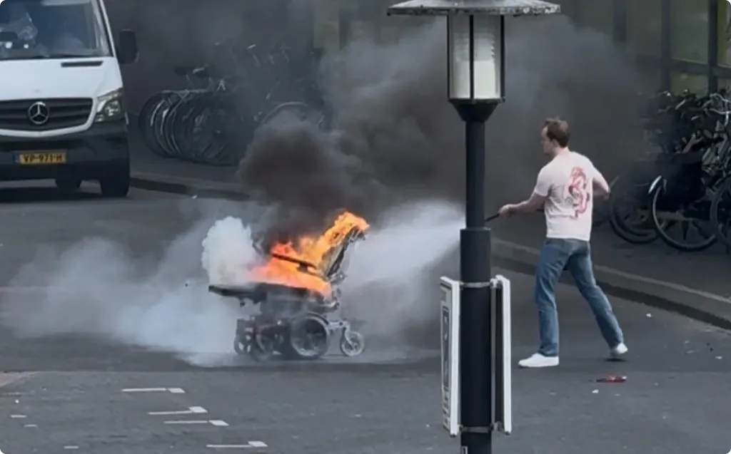 Een omstander blust het voertuig met een brandblusser Beeld: Intisar Maddoe