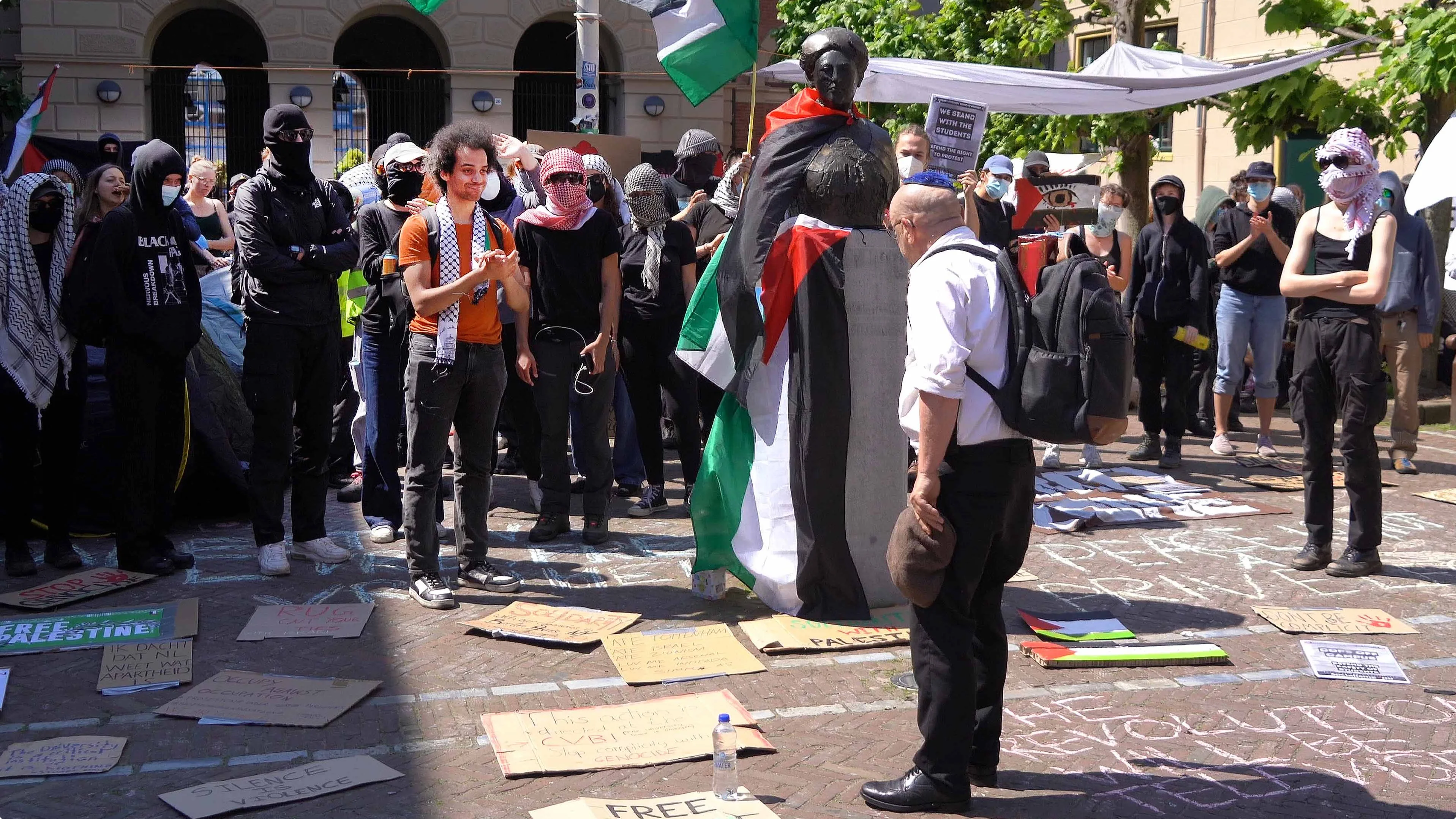 Een joodse man staat maandag voor een groep demonstranten bij de Rijksuniversiteit in Groningen - beeld: Harm Meter