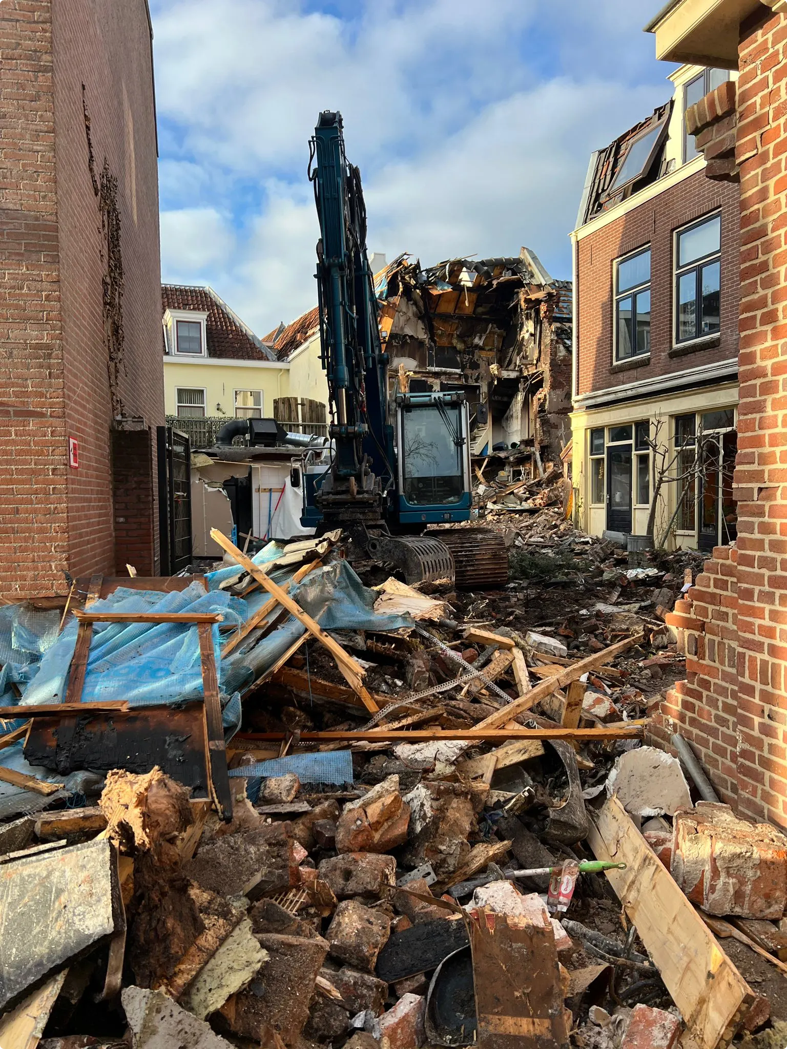 Graafmachines slopen deels het getroffen pand. Dat is geen makkelijk karwei omdat de ruimte in de krappe steeg beperkt is. Beeld: Hart van Nederland/ Esther Monsma